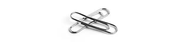 Two silver paper clips on a white background / Deux trombones argentés sur fond blanc