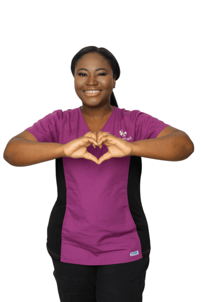 Chartwell staff in her purple uniform making a heart with her hands / L'employée de Chartwell en uniforme violet fait un cœur avec ses mains